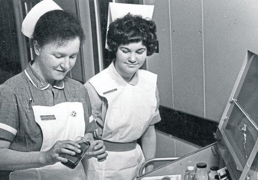 Staff Nurse I. R. Dufour, from Switzerland, does the rounds with nurse M. J. Campbell