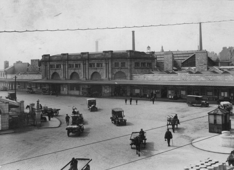 Horses and carts and more modern vehicles come and go from Aberdeen's Joint Station in the late 1800s.