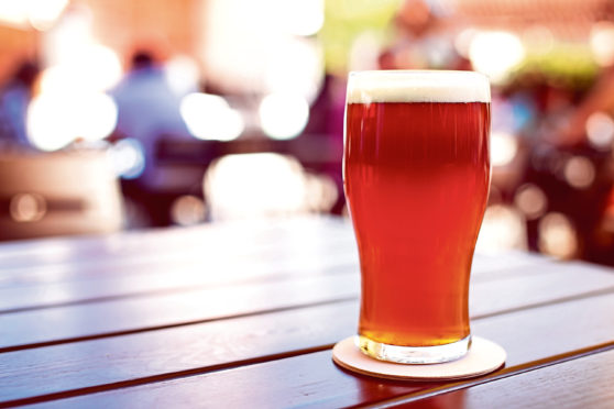 Pint of crafted ale on wooden table in beer garden; Shutterstock ID 338385629; Purchase Order: -