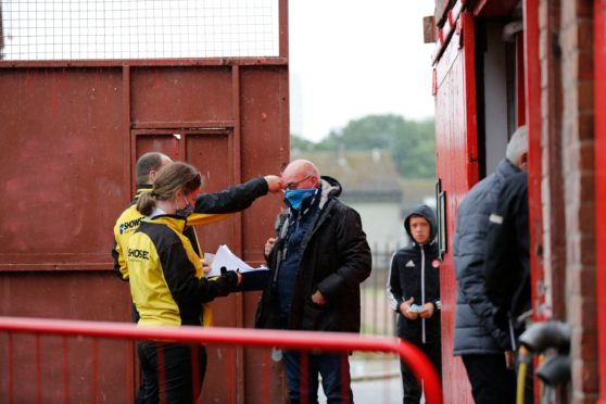 Willie Miller has his temperature checked ahead of the Ladbrokes Scottish Premiership match between Aberdeen and Rangers at Pittodrie Stadium.