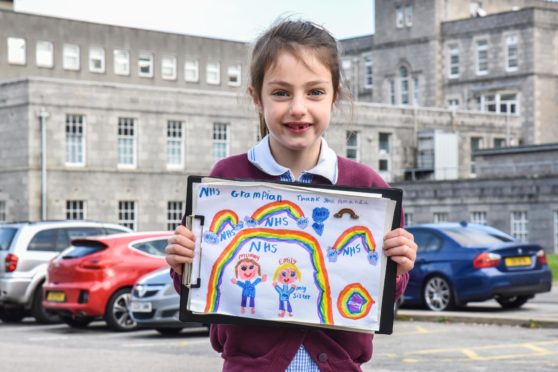 Seven-year-old Rose Donnelly with her thank you NHS drawing, which has been turned into a flag. Picture courtesy of University of Aberdeen/NHS Grampian