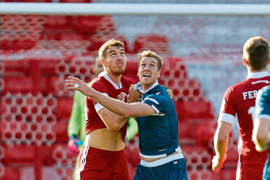 Aberdeen defender Tommie Hoban and Motherwell's Jordan White challenge for the ball.