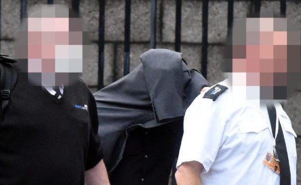 Sean Donaldson hid beneath a jacket as he was led away from court.