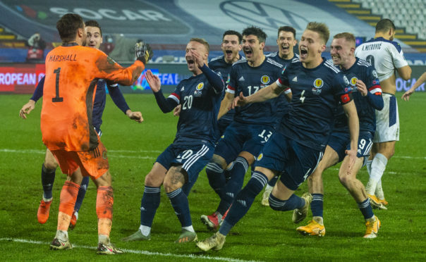Scotland's players celebrate after David Marshall saves Aleksandar Mitrović's penalty to secure Euros qualification.
