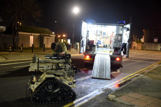 Bomb disposal experts leaving the scene in Torry tonight.
Picture by Paul Glendell