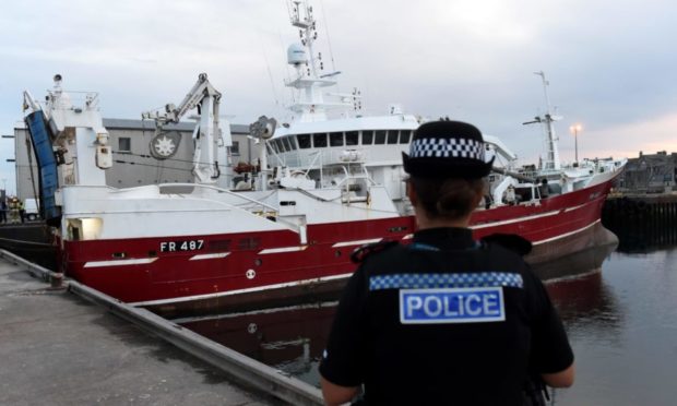 A police officer standing beside the MV Sunbeam at Fraserburgh Harbour in August 2018.