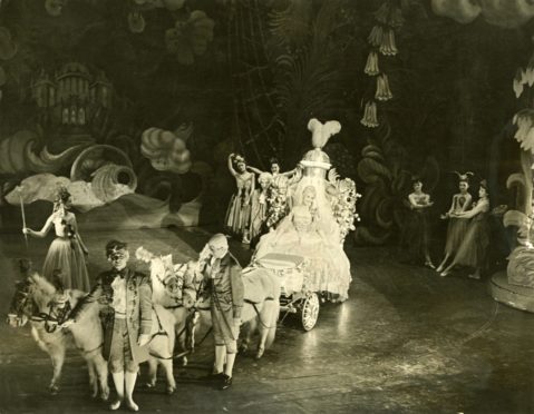 A coach and horses carry Cinderella to the pantomime ball at His Majesty's Theatre, Aberdeen in 1955.