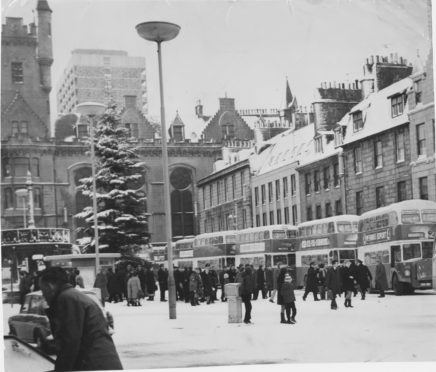 1970 The storm brought buses to a halt in Aberdeen, where many streets remained unsanded owing to the dust driver's strike. Confused passengers disembark while drivers and conductors gather at the transport inspectors' kiosk for instructions.