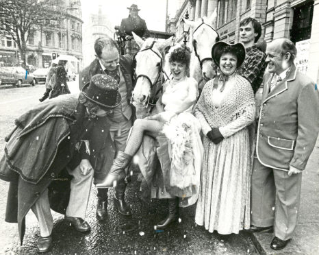 1988: Lyric Musical Society hostess Mary Webster shows a leg to some of the cast outside the theatre.