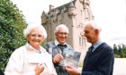 1991年:克莱斯城堡的10万名幸运游客中，罗伯特·麦克米兰和他的妻子佩吉从城堡的管理者杰弗里·鲍伊(右)那里获得了苏格兰国家信托的会员资格。历史悠久的克拉西斯城堡为一位特殊的游客提供了特别的欢迎。它的所有者请鲍勃·麦克米兰(Bob McMillan)和他的妻子佩吉(Peggy)成为国民信托基金会(National Trust)一年的家庭成员，并享用了一顿精美的午餐。因为他是城堡这个季节的第10万名访客。鲍勃是邓迪区议会的一名维护人员，他在和朋友们度假时开车进入了公园，这让他吃了一惊。