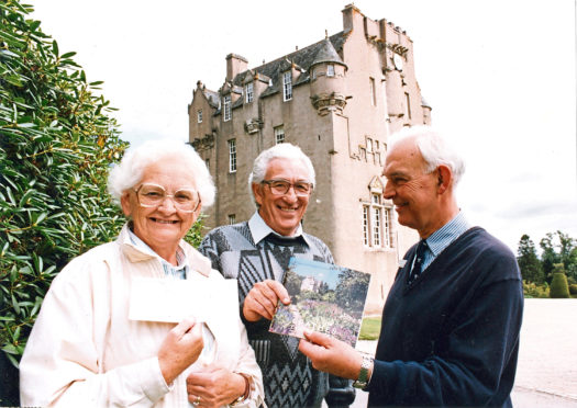1991: Lucky 100,000ths visitors to Crathes Castle, Robert McMillan and his wife Peggy receive membership of the National Trust for Scotland from Jeffrey Boughey (right), administrator at the castle.
Historic Crathes Castle has given a very special welcome to a very special visitor.
Its owners treated Bob McMillan and his wife Peggy to a years family membership of the National Trust and a slap-up lunch.
For he is the castles 100,000th visitor of the season.
Bob, a maintenance officer with Dundee District Council, was taken by surprise when he drove into the grounds during a holiday with friends.