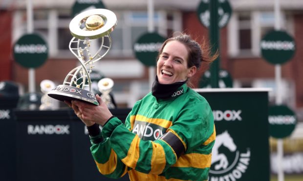 Jockey Rachael Blackmore receives the Randox Grand National Handicap Chase trophy.