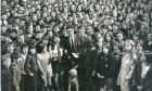 1970年的今天，在阿伯丁希尔顿学校大厅，弗里达·里奇递给希尔顿中学的学生们一张给盲人导盲犬协会的250英镑支票后，他们与j·斯金纳先生和他的狗Jasonu在一起。