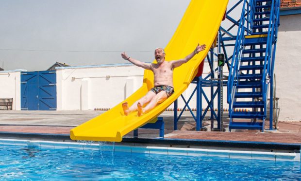 Friends of Stonehaven Open Air swimming pool group's chairman Pete Hill speed testing the new chute at the grand reopening