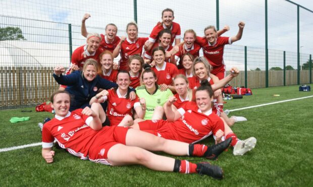 The Aberdeen FC Women squad celebrate after winning the title at Dundee United