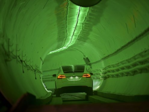 A modified Tesla Model X drives in the tunnel entrance before the unveiling event for the Boring Co Hawthorne test tunnel (Robyn Beck/Pool Photo via AP)