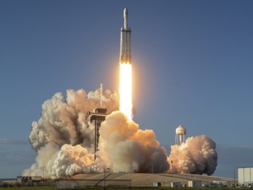 A SpaceX Falcon Heavy rocket carrying a communication satellite lifts off (Craig Bailey/Florida Today via AP)