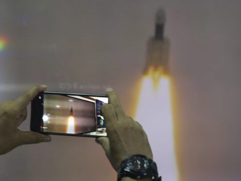 A man at New Delhi’s Nehru Planetarium takes pictures of a web cast of the lift off (Manish Swarup/AP)