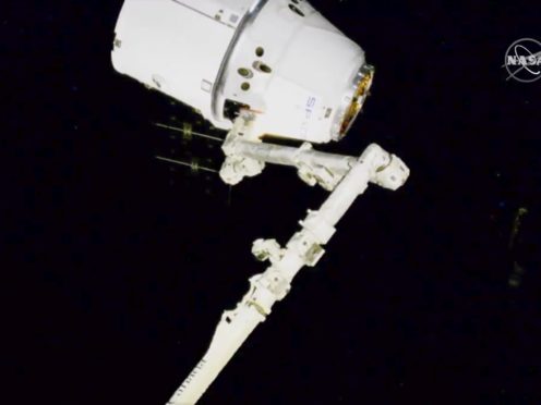 Nasa astronauts Andrew Morgan and Jessica Meir use the International Space Station’s robot arm to capture the Dragon capsule (Nasa/AP)