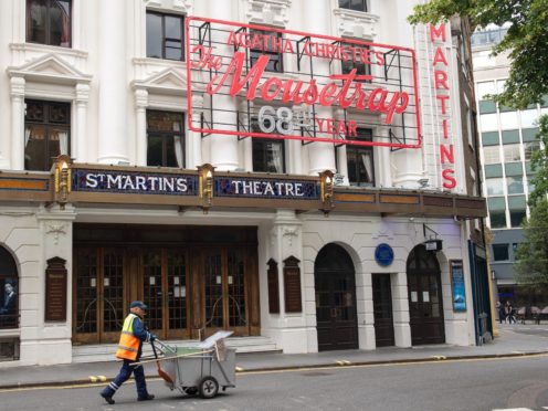A street cleaner walks past the closed St Martin’s Lane theatre (Dominic Lipinski/PA)