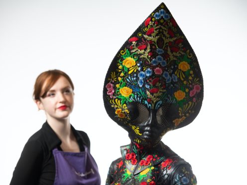 Auctioneer Lucy Bishop views the ‘Floral Alien’ costume worn by Lady Gaga for her music video ‘911’ (Dominic Lipinski/PA)