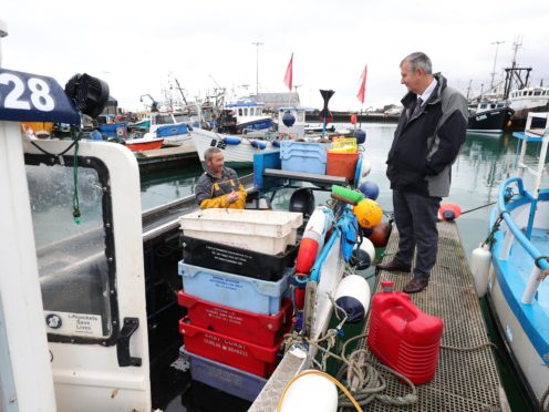 Agriculture Minister Edwin Poots (right) talks to fisherman Robert Oates (left) at Portavogie Harbour (Press Eye/PA)