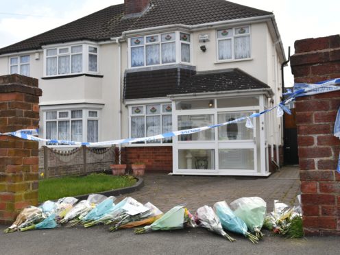 Flowers outside the house on Boundary Avenue in Rowley Regis, West Midlands, where a woman in her 80s died after being attacked by two escaped dogs (Jacob King/PA)