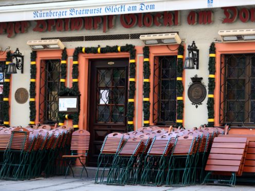Chairs and tables outside a traditional Bavarian restaurant are locked at the city centre in Munich, Germany (Matthias Schrader/AP)