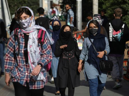 People wear protective face masks to help prevent the spread of coronavirus (Vahid Salemi/AP)