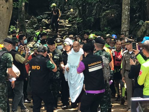 Rescuers help Phra Manas walk out from the Tham Phra Sai Ngam cave (AP)
