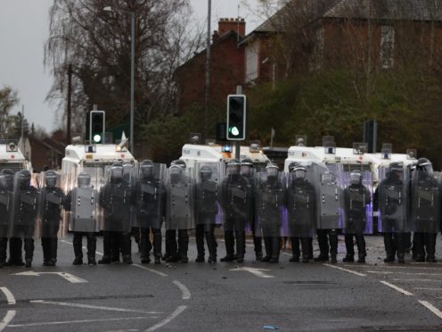PSNI officers with riot shields line the Springfield road, during further unrest in Belfast (Liam McBurney/PA)