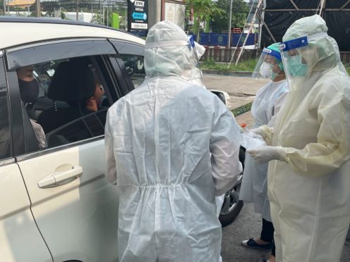 Medical workers carry out swab tests at a drive-through Covid testing facility outside a hospital in Nonthaburi, Thailand (Kiko Rosario/AP)
