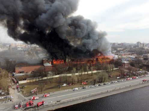 Smoke and flames rise from a building in St Petersburg, Russia (Dmitri Lovetsky/AP)