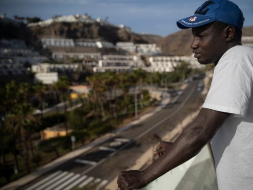 Senegalese migrant Fode Top looks at the view from the hotel room at Holiday Club Puerto Calma in Puerto Rico de Gran Canaria, Spain (Renata Brito/AP)