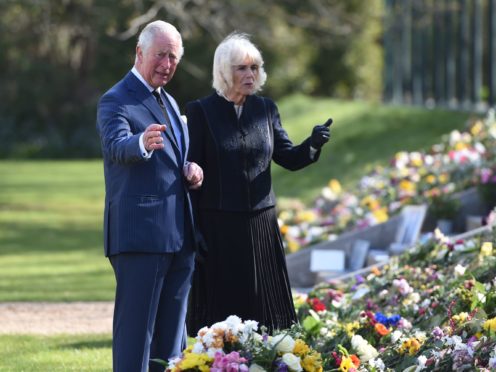 The Prince of Wales and the Duchess of Cornwall view flowers left in tribute to the Duke of Edinburgh (Jeremy Selwyn/Evening Standard/PA)