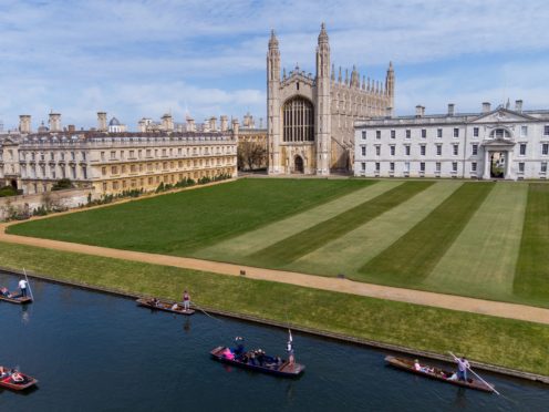 People enjoy a punt tour past King’s College on the River Cam in Cambridge (PA)