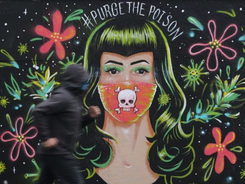 A jogger passes a mural by Brazilian artist Gabriel Marques in Dublin’s Grand Canal area, during Covid-19 lockdown (Niall Carson/PA)
