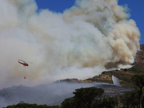 A helicopter drops water over a fire at Rhodes Memorial on Table Mountain, Cape Town (Nardus Engelbrecht/AP)