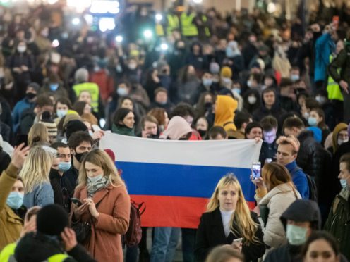 People hold a Russian flag during the opposition rally in support of jailed opposition leader Alexei Navalny in Moscow (Pavel Golovkin/AP)
