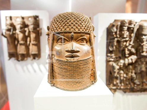 Three pieces of Benin Bronzes are displayed at Museum for Art and Crafts in Hamburg, Germany, Wednesday, Feb. 14, 2018. Germany is returning hundreds of artifacts known as Benin Bronzes that were mostly looted from western Africa by a British colonial expedition and subsequently sold to collections around the world, including German museums. (Daniel Bockwoldt/dpa via AP)