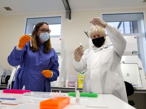 Prime Minister Boris Johnson looks at samples during a visit to Porton Down (PA)