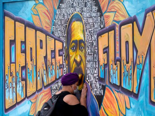 A woman pays her respects at a mural at George Floyd Square in Minneapolis on Friday (Julio Cortez/AP)