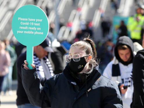 A steward in a mask outside Wembley stadium asks fans for Covid-19 test results (Gareth Fuller/PA)