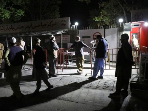 Afghans wait outside to see their relatives after the suicide blast (AP)