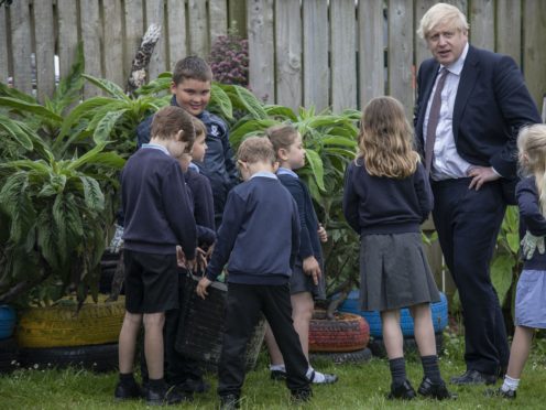 Prime Minister Boris Johnson talks with primary school children in the outdoor spaces at the St Issey C of E Primary school near Wadebridge in Cornwall (Jack Hill/The Times/PA)