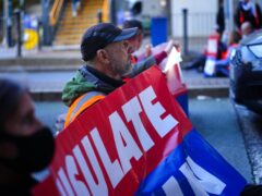 Protesters from Insulate Britain blocking a road near Canary Wharf in east London (PA)