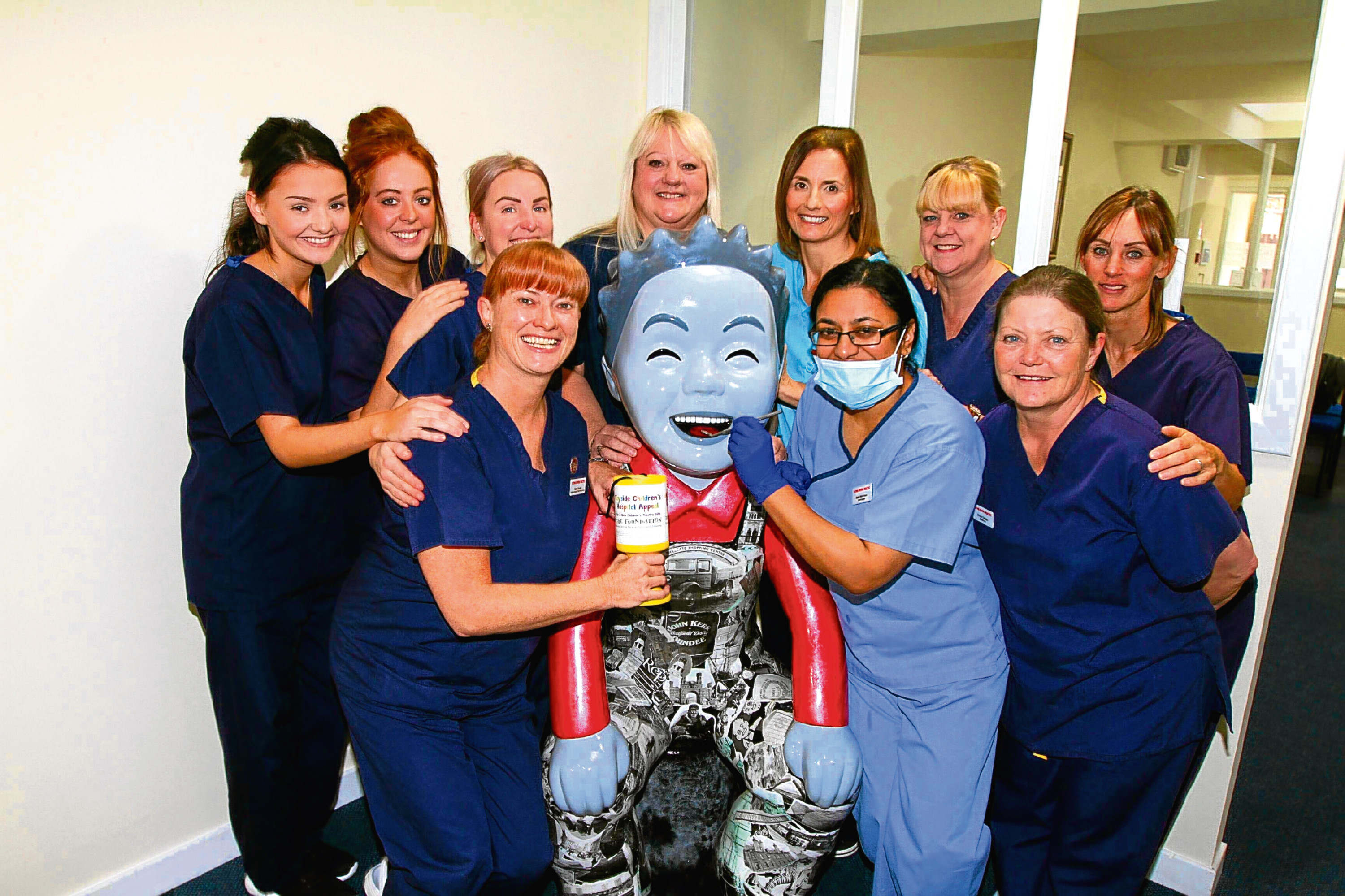 Past and Present Oor Wullie at Duthie Dental Practice along with staff members.