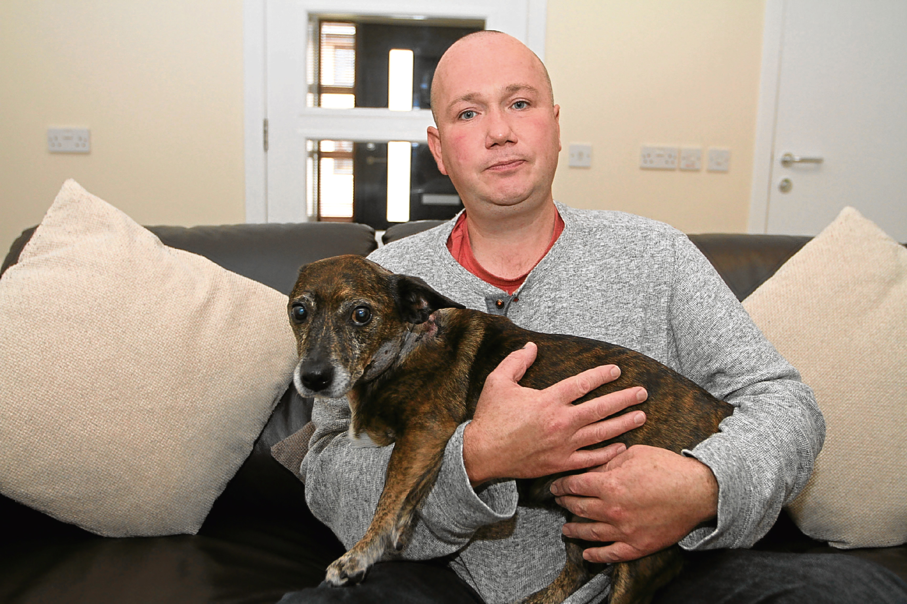 Chris Rae pictured at home with his dog Dino shortly after the attack in September.