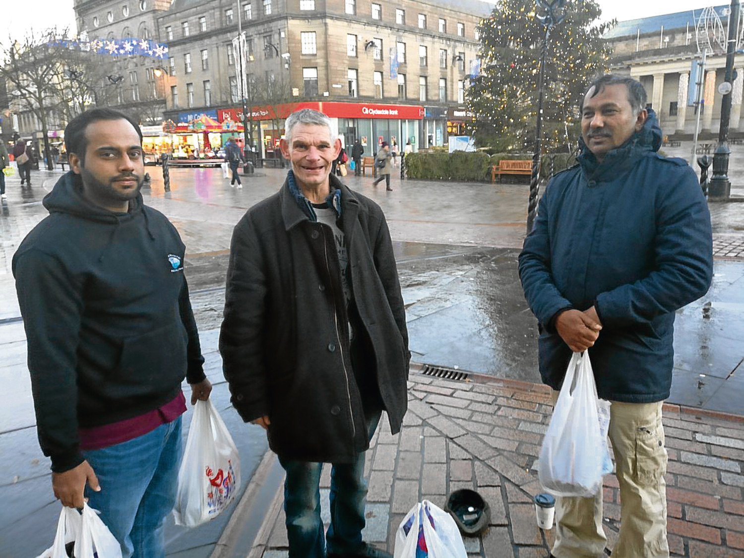 Naseh Ahmed (left) and Dr Golam Kabir, volunteers with the Dundee AMYA, speak to a member of the Dundee homeless community in the city centre.