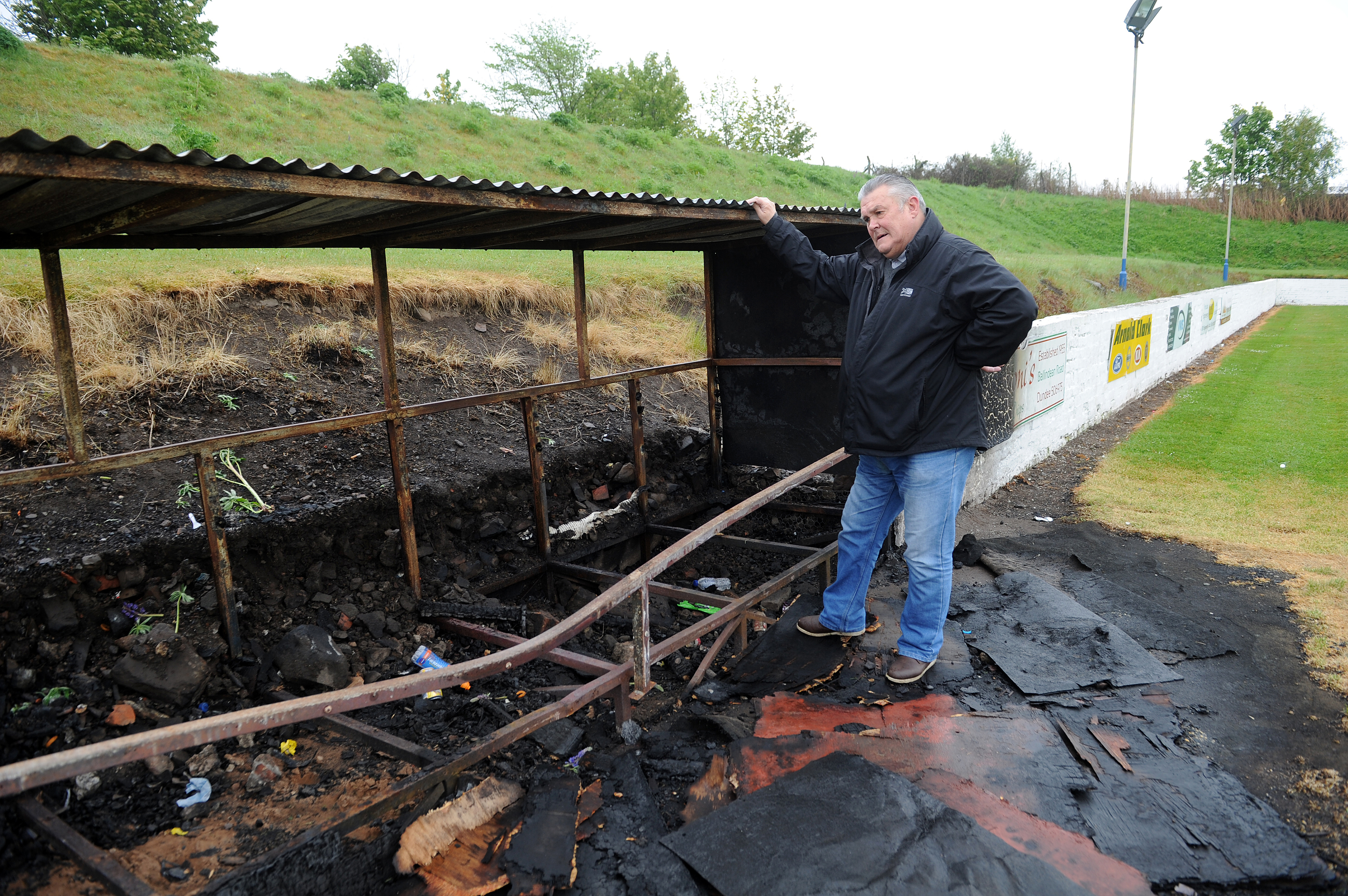 Club secretary Brian Coutts next to the fire-damaged dugout.